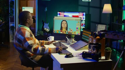 Creative african american graphic designer editing images on dual monitors, showcasing talent and dedication to the digital design field in a well organized home workspace. Camera B. - Powered by Adobe
