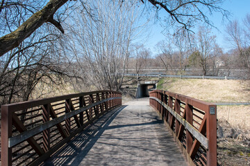 A paved path at a local Minnesota park leads to a walking bride during Autumn.