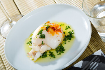 Plate of roasted Cuttlefish served with olive oil and garlic sauce and greens