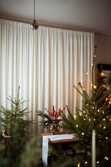 Long beige white candles in a candlestick with brown velvet bows. Christmas trees and fir tree...