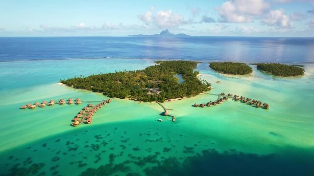 Drone Tahiti. Aerial view of Tahaa island lagoon, overwater bungalows in clear ocean water, Bora Bora island in background. honeymoon vacation, romantic tourism destination in French Polynesia. 