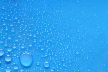 Water drops on blue background, top view