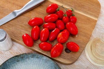 Fresh cherry tomatoes ready for cooking on wooden table