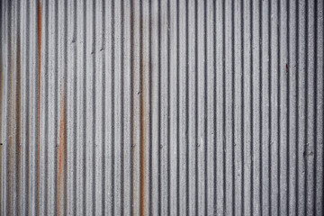 Zinc texture. Closed up details of silver zinc plate with small wavy pattern texture and metal sheet background. Small tear rusty corrugated metal wall texture