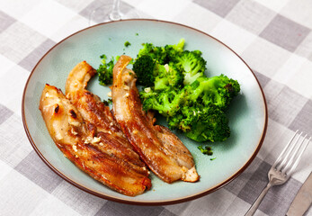 Delicious roasted pork belly served with broccoli on plate..