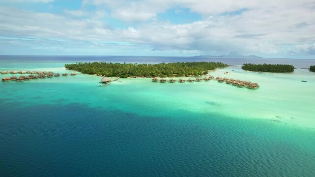 Drone Tahiti. Aerial view of Tahaa island lagoon, overwater bungalows in clear ocean water, Bora Bora island in background. honeymoon vacation, romantic tourism destination in French Polynesia. 