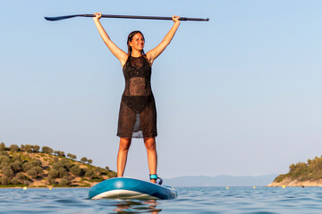 Healthy happy  woman relaxing on a sup surfboard. A beautiful teen girl rows in a calm sea.  Summer...