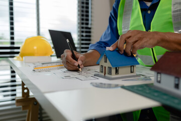 Fototapeta premium a contractor is checking the first draft in his office, architect is examining blueprint to make sure that everything correct in the workplace, an engineer is working on his project