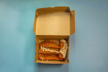 Crunchy banana cake, sweet banana cake with sweet topping, banana cake in a box and blue background