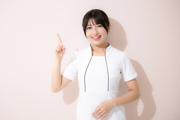 エステや美容ナースなどポイントやオススメのポーズ　ピンク背景のカメラ目線