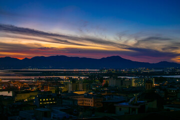 view of the city with sunset around the port in Cagliari, Italy