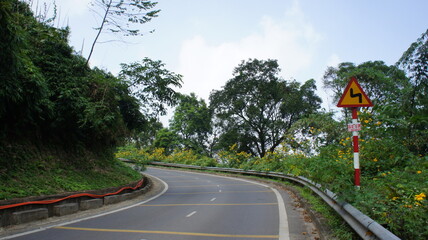 Scenic Winding Mountain Road with Hairpin Turn and Warning Sign