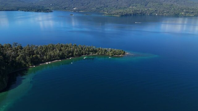 aerial view of Lynch Bay in the Arrayanes Forest, located within Nahuel Huapi Lake in Patagonia, Argentina. The pristine blue waters contrast with the lush green forest.