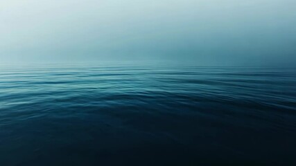 The image is of a calm body of water with a blue color. The water is still and peaceful, creating a serene atmosphere