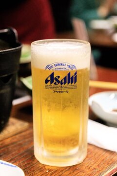 Aomori, Japan - June 1st 2024 - Photo of a Chilled Asahi Beer Glass on a Wooden Table in a Restaurant