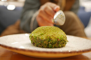 A Gourmet Dish Featuring an Exquisite Pistachio Coating is Being Artistically Garnished
