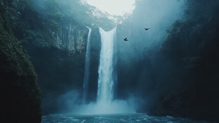 Fototapeta premium Majestic Waterfall Surrounded by Lush Green Forest and Mist, Capturing the Serenity of Nature in a Beautiful Landscape