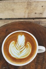  a cup of latte art coffee on wooden background                                                                                                                                                  