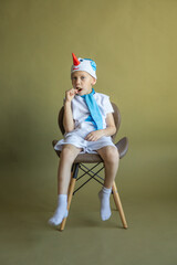 Obraz premium boy sitting in a snowman costume with a lollipop
