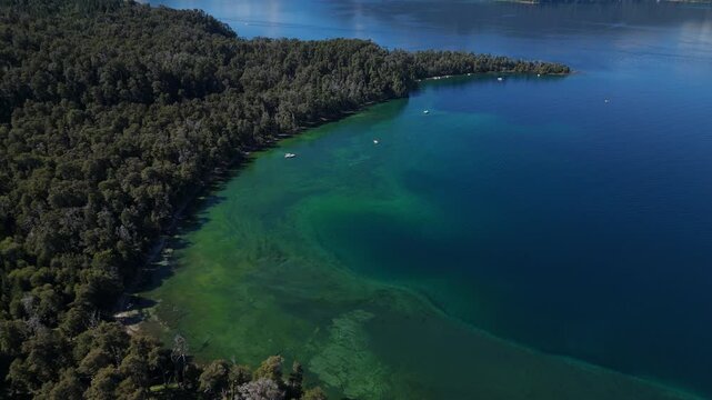 aerial view of Lynch Bay in the Arrayanes Forest, located within Nahuel Huapi Lake in Patagonia, Argentina. The pristine blue waters contrast with the lush green forest.