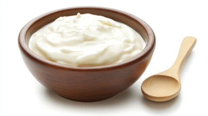 A bowl of creamy yogurt with a wooden spoon, ready for serving or cooking.