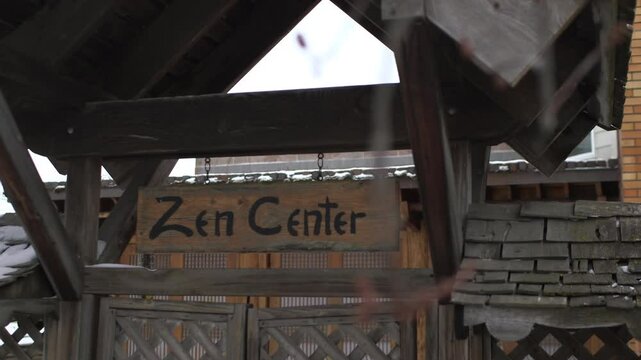 Zen Center Wooden Sign on Dark Wood Building with Triangular Roof Exterior