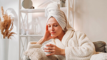 Spa thinking. Fresh time. Relaxed young girl in bath towel and white soft robe enjoying rest...