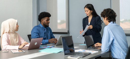 Diverse team of professionals collaborating on project in modern office discussing ideas with focus on innovation and teamwork, multi-ethnic group, business strategy, corporate meeting, brainstorming