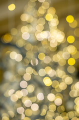 The image is a blurry Christmas tree with many golden and yellow lights