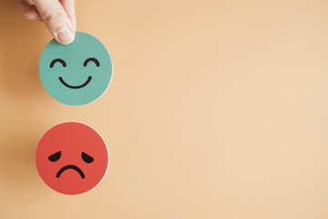 Hand choosing happy smile face, good feedback rating and positive customer review, mental health...