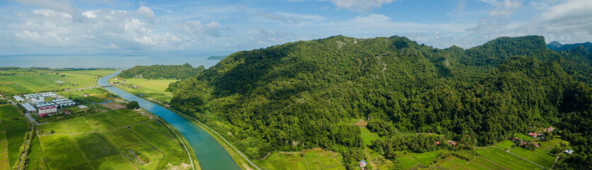Obraz premium Panoramic aerial drone view of countryside with green paddy crops at Kampung Wai, Perlis, Malaysia