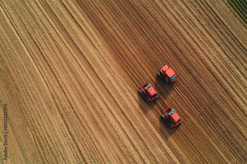 Aufkleber Automated farming machines work diligently to plant crops across a large field, creating systematic furrows in the earth. Generative AI