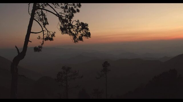 A sunset behind the mountain ridges, taken from the top of a mountain, with shades of purple