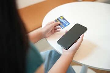 Asian woman with smart phone for online shopping.  Hand holding mobile phone with Payment on credit card online shopping electronic wallet Payment Shopping by phone connected card concept