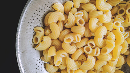 Boil the pasta and use a strainer to separate from the water. Macaroni ready to cooking. Food ingredient recipe.