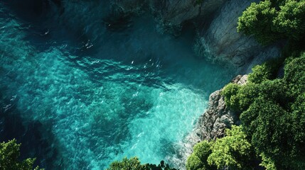 Obraz premium Aerial view of a serene shoreline showcasing crystal-clear turquoise waters contrasting with lush green foliage, perfect for nature and tropical getaway themes.