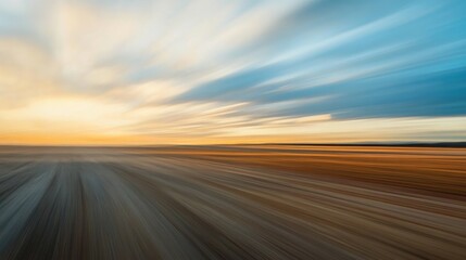 Motion blur of a racetrack captured at golden hour, highlighting dynamic movement with vibrant orange and blue sky gradients.