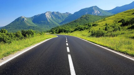 Naklejka premium Winding asphalt road curves through vibrant green mountains under a bright blue sky, showcasing a serene natural landscape.