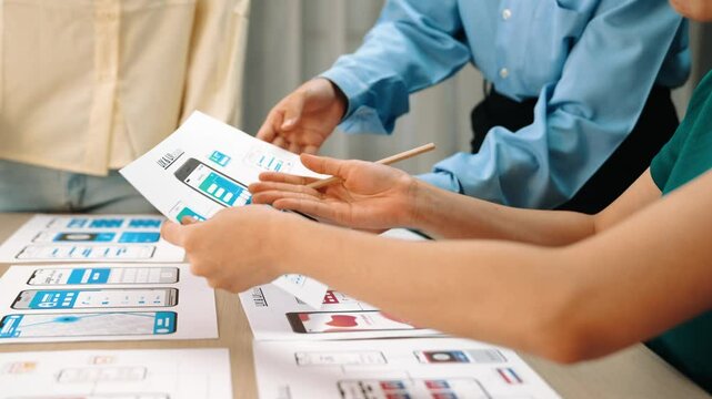 Panorama video of startup UX developer or company employee design user interface or UI prototype for mobile application or website software with software display on smartphone in office. Synergic