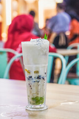 Ice or Es Teler on the table with blurred people background