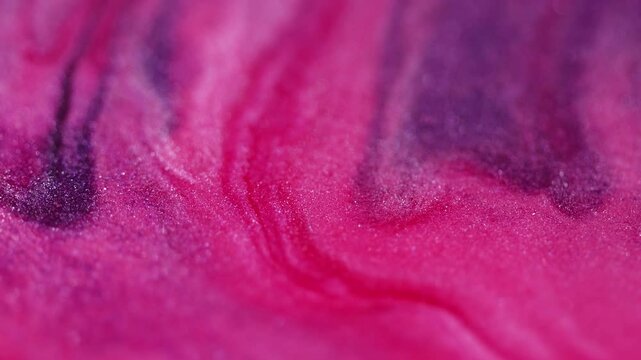 Glitter gel fluid. Sparkling flow. Defocused pink dark blue color shiny sequin particles transparent emulsion wave motion bokeh light texture abstract art background.