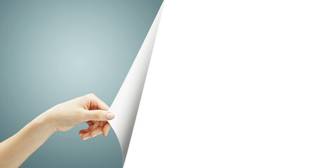 A hand turns a white page, revealing a blank space on the right side with a blue gradient...