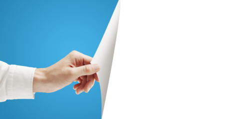 A hand holding and turning a blank white sheet of paper, with a blue background on the left side and white space on the right. Concept for layout