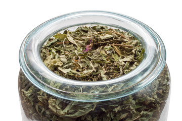 Crushed mint leaves in a glass jar. Fragrant herbs on a white background.