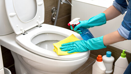 Close up - Hands in glove rubber of woman cleaning and sanitizing toilet