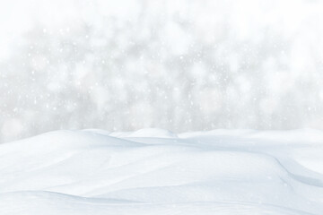 Fresh clean snow falls against the background of a forest and a snowdrift. Winter colorful landscape. Heavy snowfall concept.