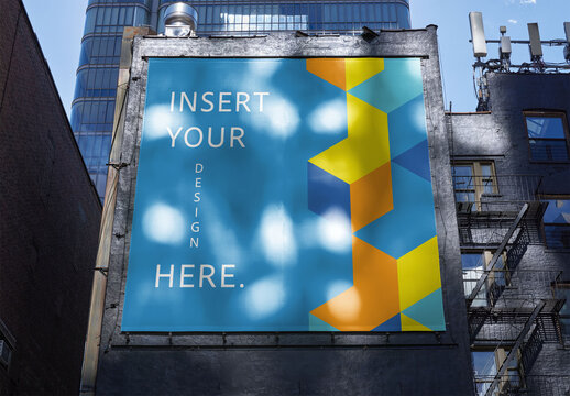Empty Billboard on a Building in New York Reflecting the Sun. PSD Mockup Template for wallscape adverstising