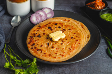 Aloo paratha is a popular North Indian dish, especially in Punjab, Uttar Pradesh, and Bihar. It's a stuffed flatbread with spiced mashed potatoes, served with butter and tangy achar (pickle).