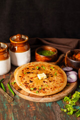 Aloo Paratha is a popular North Indian dish, especially in Punjab. It’s a flatbread stuffed with spiced mashed potatoes, served hot with tangy pickle (anchar) and flavorful chutney