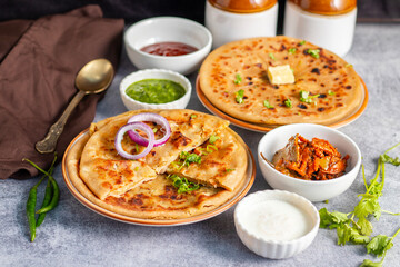 Aloo Paratha is a popular North Indian dish, especially in Punjab. It’s a flatbread stuffed with spiced mashed potatoes, served hot with tangy pickle (anchar) and flavorful chutney